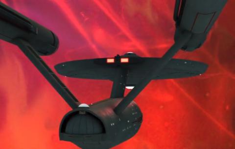 Starship Enterprise flying into a purple/red "space amoeba"