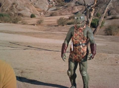 A person in a green monster body suit in the desert near Los Angeles