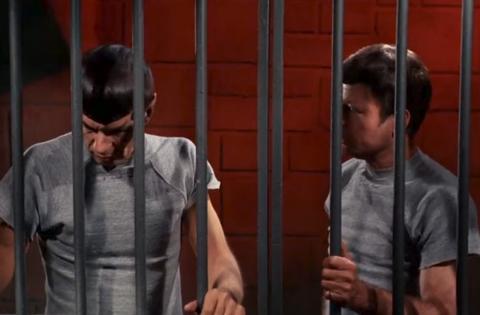 Spock and McCoy standing in a jail cell