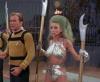 Captain Kirk and a woman with large hair and silver cat suit.
